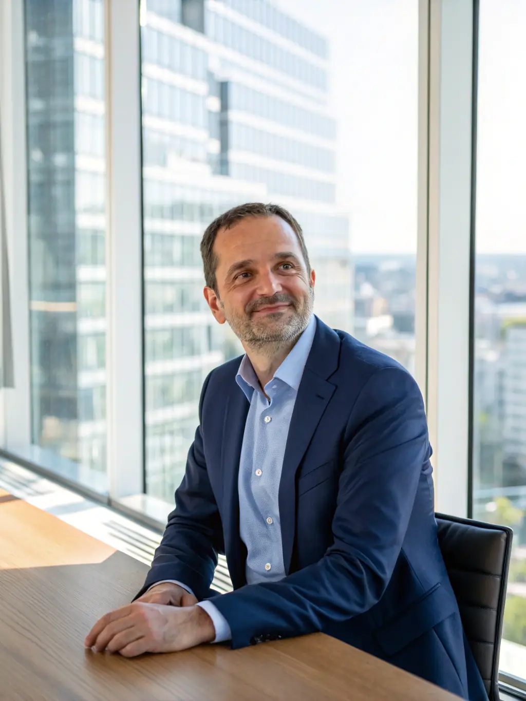 A professional headshot of a C-level executive in a modern office setting, symbolizing strategic leadership and decision-making within the Primis Kompass Community.